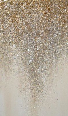 gold glitter is falling from the ceiling in front of a white wall and flooring