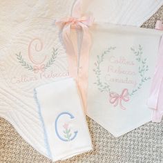 three personalized towels and two handkerchiefs on the floor next to each other with ribbons