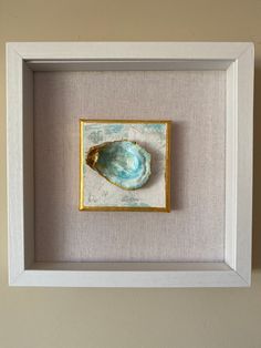 a white frame with a blue and gold shell in it