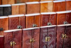 rows of leather bound books lined up in rows with brass hardware on the front and sides