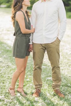 a man and woman standing next to each other in the grass