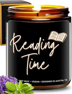 reading time soy candle next to an open book and purple flowers on a white background