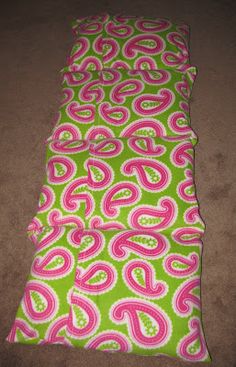 the pink and green paisley print is laying on the floor