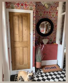 a dog is standing in front of a door with a welcome mat on the floor