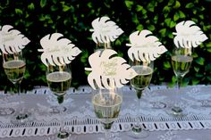 there are many wine glasses on the table with place card holders in front of them