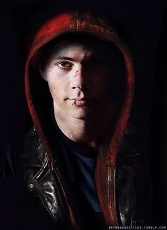 a man in a leather jacket with a red hoodie over his face and nose