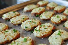 there are many small pieces of food on the baking sheet in the pan, with parsley sprinkled on top