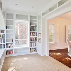 an empty room with many bookshelves and windows