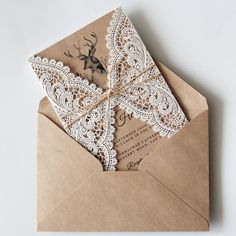 an open envelope with a white lace and deer on the inside, tied in twine