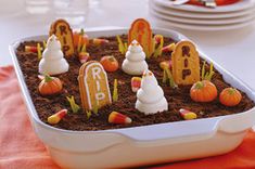 a cake in the shape of letters and pumpkins on top of dirt with grass