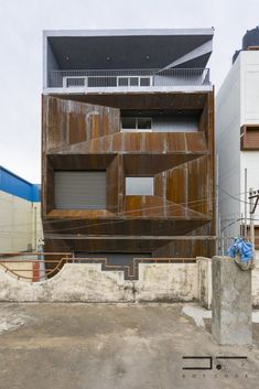 an old building has been transformed into a modern home with steel cladding and concrete columns