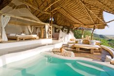 an outdoor pool with lounge chairs and a canopy over it