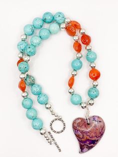 ADORABLE necklace!! Perfect for a romantic night out!! This PCJ designed and handmade necklace consists of a purple crazy lace agate heart focal wire wrapped with turquoise magnesite, orange carnelian flat round beads and sterling silver beads. Measures 20.5" in length. - Sterling silver - Genuine semi-precious gemstones - Measures 20.5" - Handmade by PCJ Orange Carnelian, Romantic Night, Crazy Lace Agate, Heart Soul, Lace Agate, Handmade Necklace, Precious Gemstones, Sterling Silver Bead, A Romantic