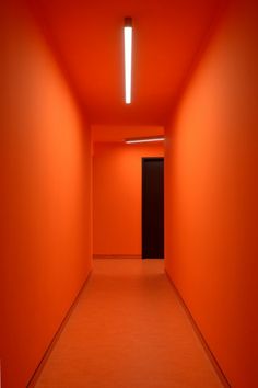 an empty hallway with bright orange walls and floor