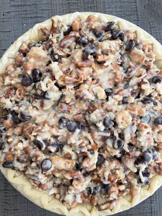 an uncooked pizza sitting on top of a wooden table covered in toppings