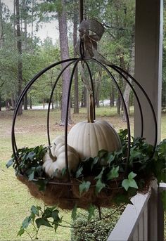 a pumpkin in a hanging basket on the porch