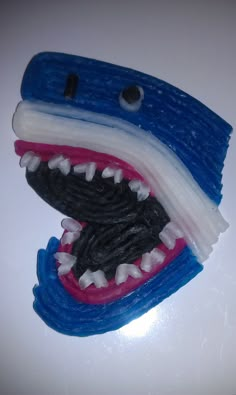 a close up of a toothbrush shaped like a shark's mouth with teeth