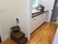 a bathroom with white walls and brown carpet on the stairs leading up to the toilet