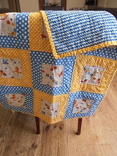 a blue and yellow patchwork baby crib with white polka dots on the sides