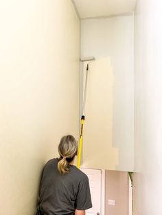 a woman is painting the walls in her home