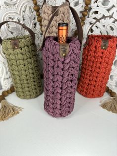 three crocheted bags sitting next to each other on top of a white table