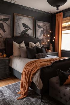 a bedroom decorated in black and orange with pictures on the wall