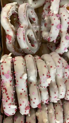 there are many donuts with white frosting and pink sprinkles on them