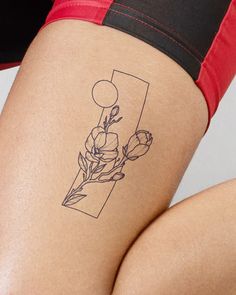 a woman's thigh with a flower tattoo on her lower leg and the letter f behind it