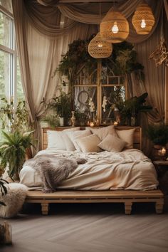 a bed with pillows and blankets in a room filled with potted plants on the windowsill