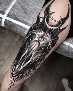 a man's leg with a black and white tattoo design on it, depicting an animal