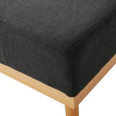 a close up view of a footstool made from wood and fabric with a black cover