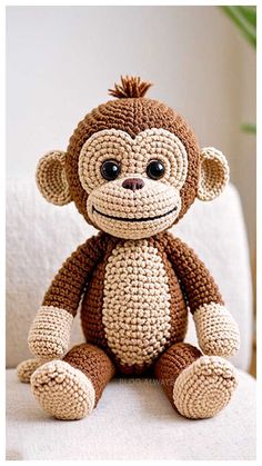 a crocheted monkey sitting on top of a white chair