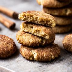 several cookies stacked on top of each other with cinnamon sticks in the background and one cookie missing