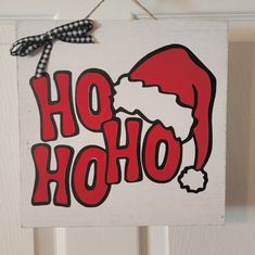 a sign that says ho hoo with santa's hat on it hanging from a door