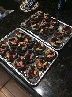 two trays filled with cupcakes on top of a counter