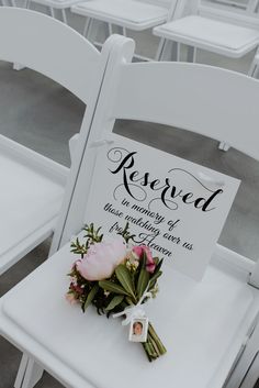 a white chair with flowers on it and a sign that says reserved to the ceremony