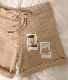 a pair of shorts with pictures attached to them on top of a white sheeted bed