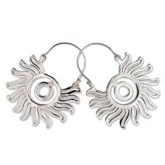 pair of silver earrings with sun design on the front and back ends, hanging from hoops