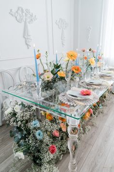 the table is set with flowers and candles