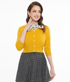 This 1950s piece features a classic button-up front and chic three-quarter length sleeves for a touch of retro flair. The versatile mustard color makes it easy to mix and match with all of your favorite outfits!Available in sizes S-2X while supplies last. Vintage Spring Cardigan For Workwear, Retro Fitted Cardigan For Fall, Vintage Button-up Cardigan For Work, Fitted Vintage Cardigan For Work, Fitted Yellow Cardigan For Fall, Retro Yellow Cardigan For Spring, Yellow Retro Cardigan For Spring, Retro Fitted Button-up Cardigan, Classic Yellow Winter Cardigan