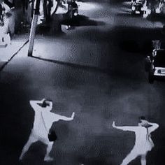 two people are dancing in the street at night