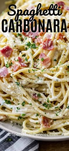 spaghetti carbonara with bacon and parmesan cheese in a white bowl on a wooden table