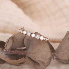 an image of a ring with pearls on it sitting on top of a flower petals