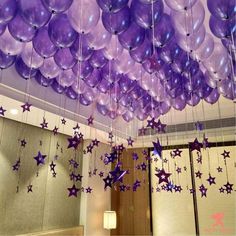 purple balloons and stars hanging from the ceiling