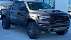 a gray truck parked in front of a building