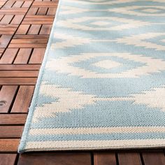 a blue and white rug sitting on top of a wooden floor