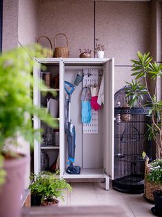 a white cabinet filled with gardening tools and plants