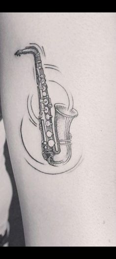 a black and white photo of a saxophone tattoo