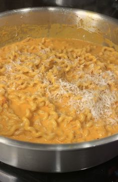 macaroni and cheese being cooked in a pot on the stove