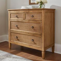 a wooden dresser with wicker drawers and a mirror on the wall above it in a room